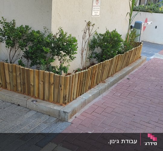 גינה קטנה עם גדר עץ ליד בניין